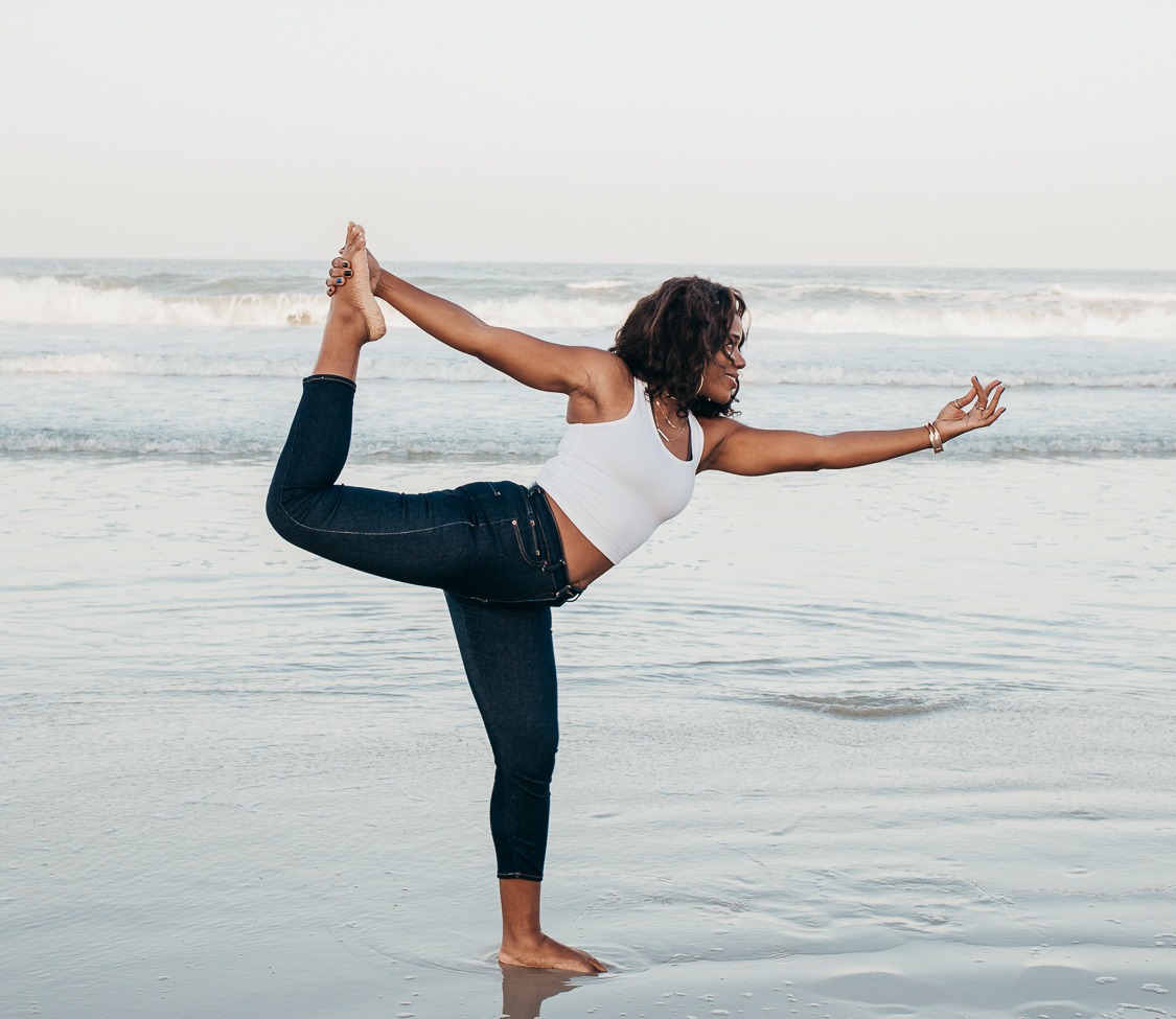 Soul Gym Founder performs a yoga pose on the beachshore with ocean in background